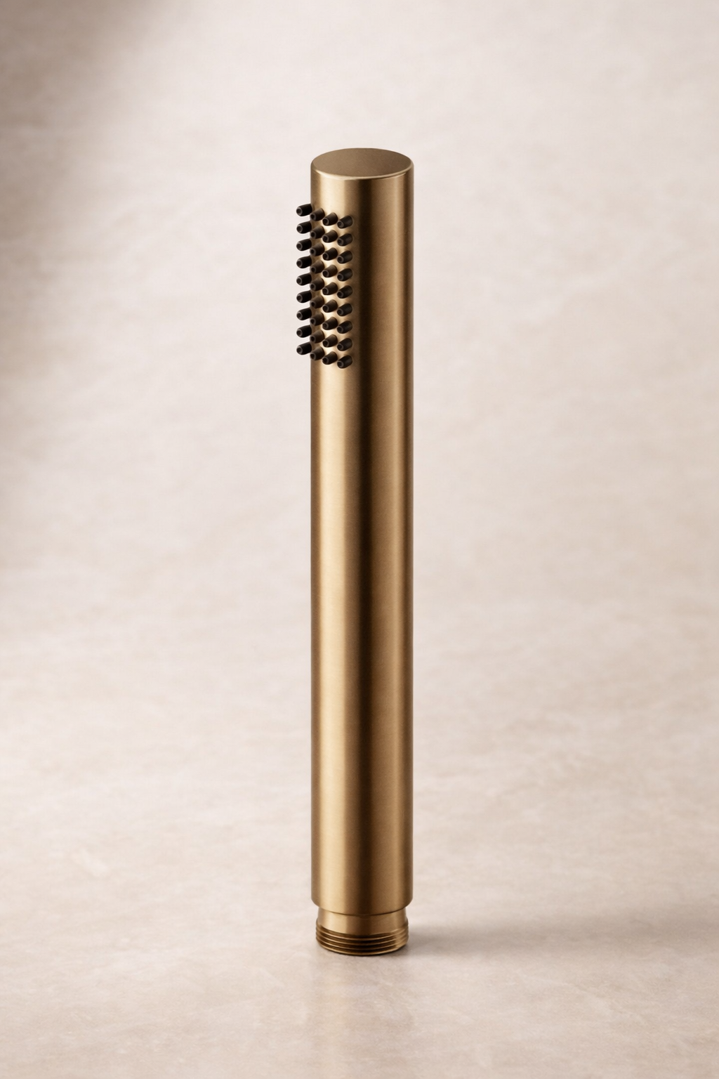 Antique Brass hand held shower head on a beige background