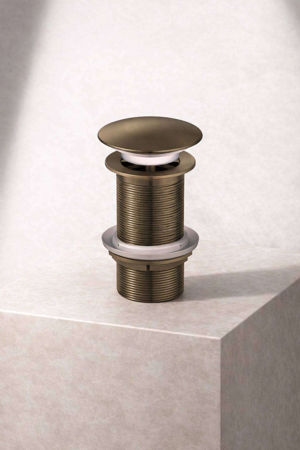 Antique brass sink drain on a light gray background