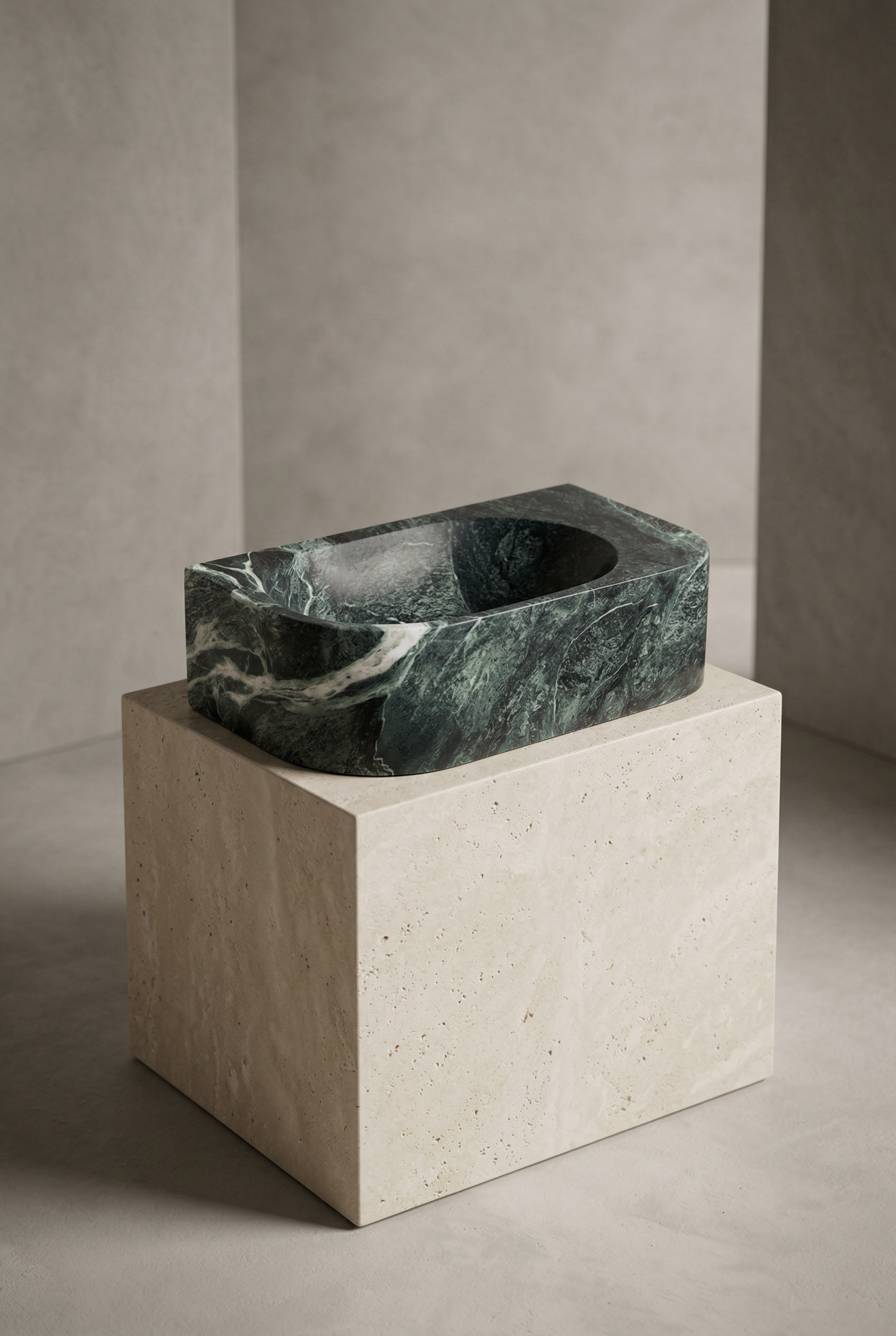 Marble sink on a stone pedestal against a neutral wall.