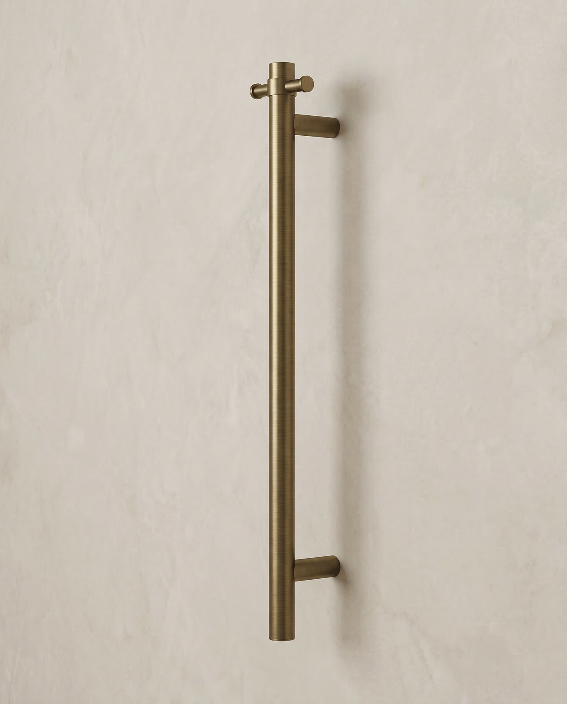 Antique Brass Heated Towel Rail on a beige wall