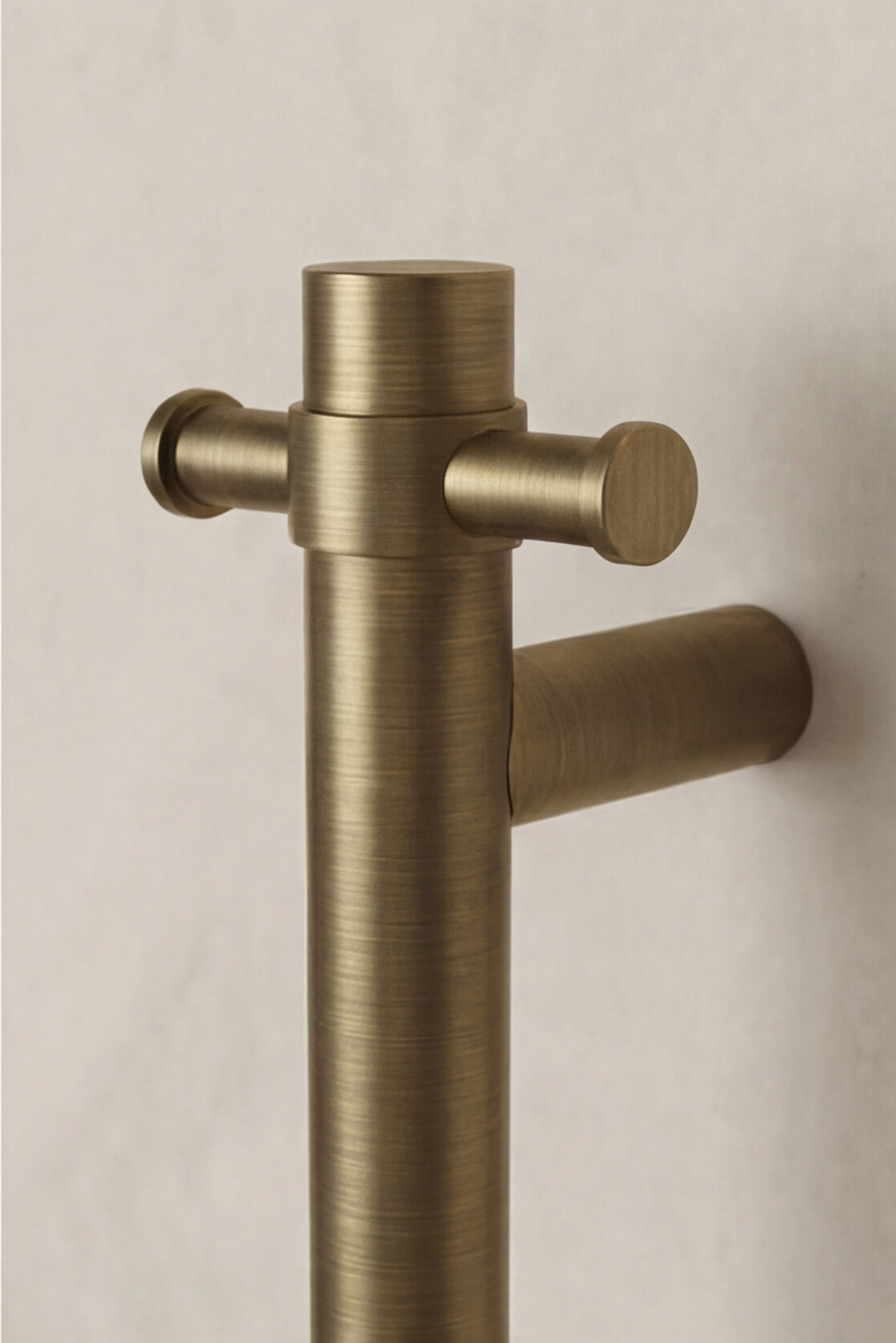 Antique Brass wall-mounted heated towel rail on a beige background