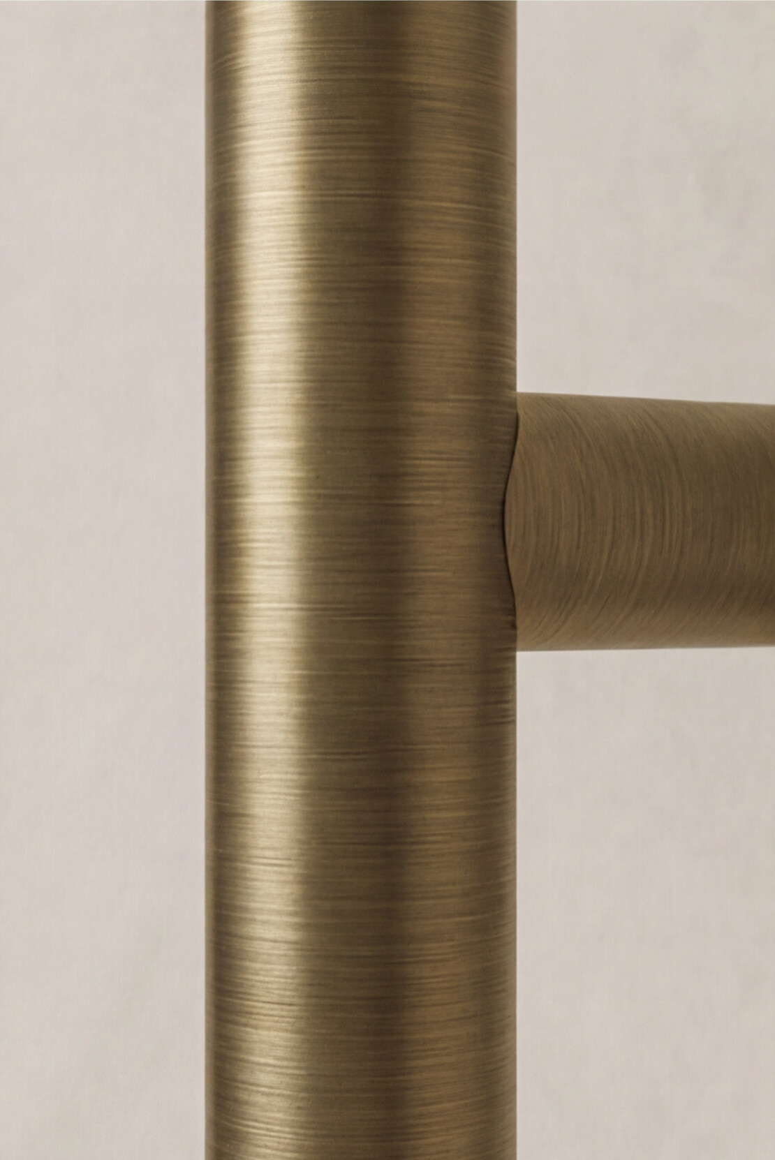 Antique Brass heated towel rail on a beige background