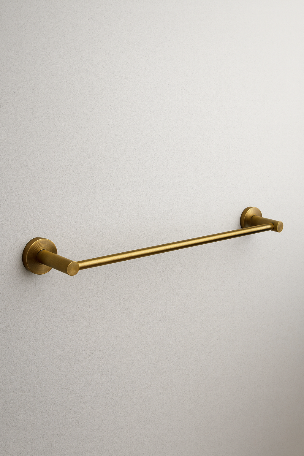 Gold towel bar on a light gray wall