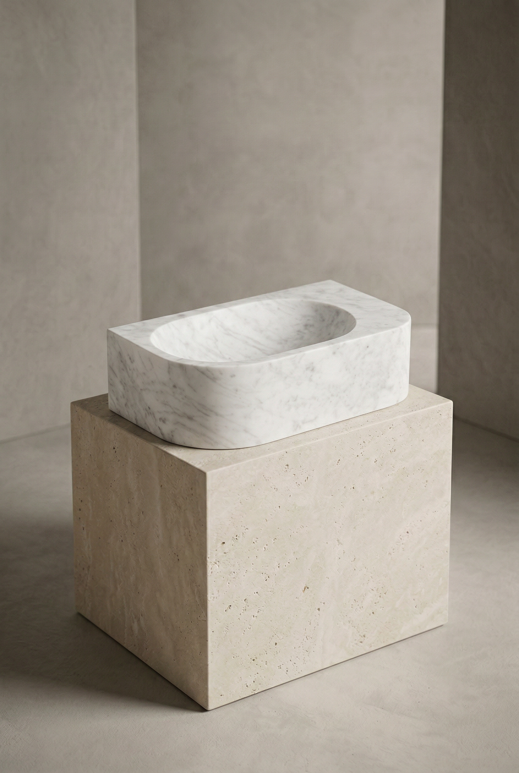 Marble sink on a stone pedestal against a neutral wall.