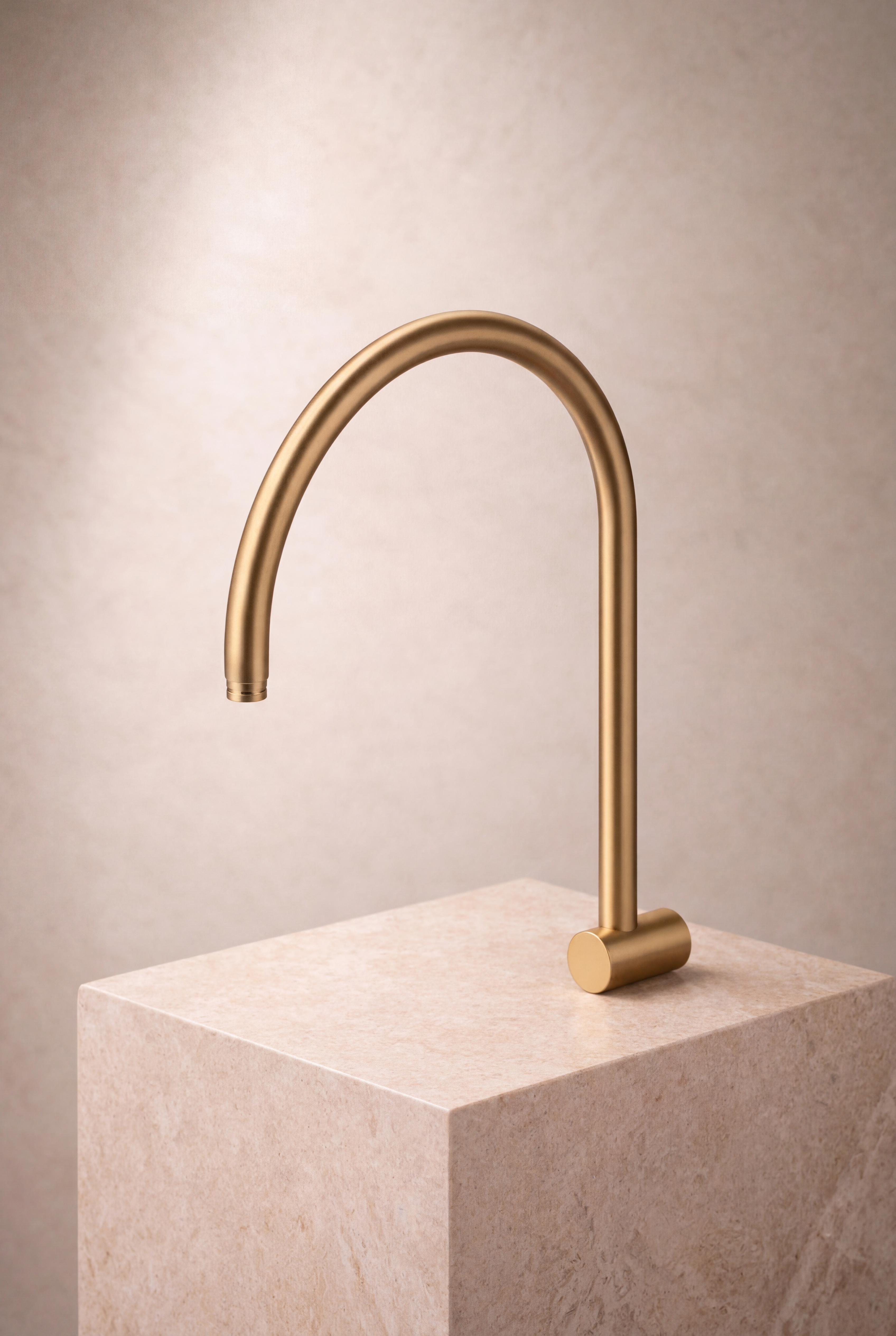Gold shower arm on a beige stone block against a beige background