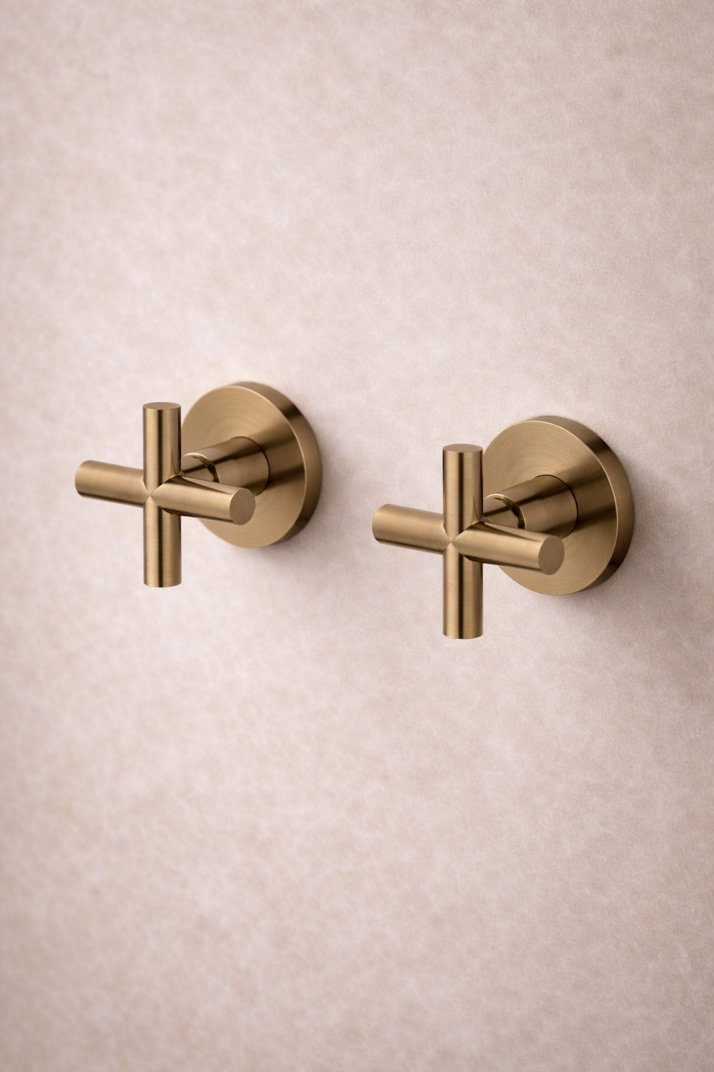 Two Antique Brass wall-mounted fixtures on a beige textured wall