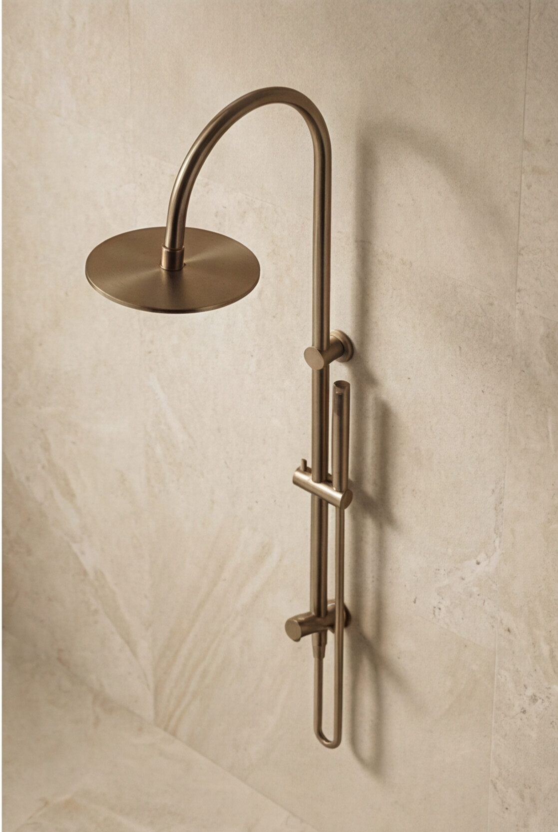 Antique Brass shower head and handheld shower on a textured wall