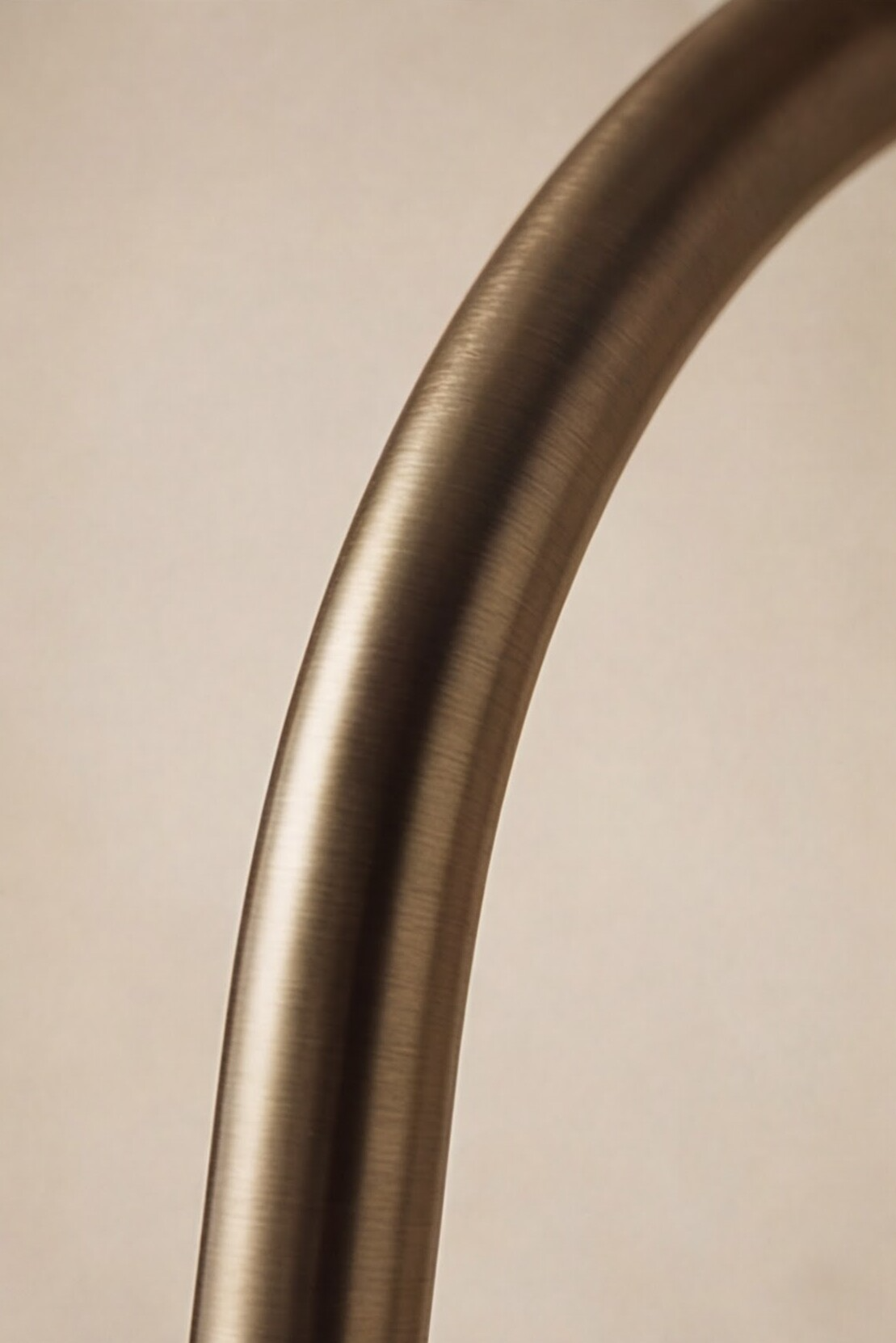 Close-up of a curved metallic object on a beige background
